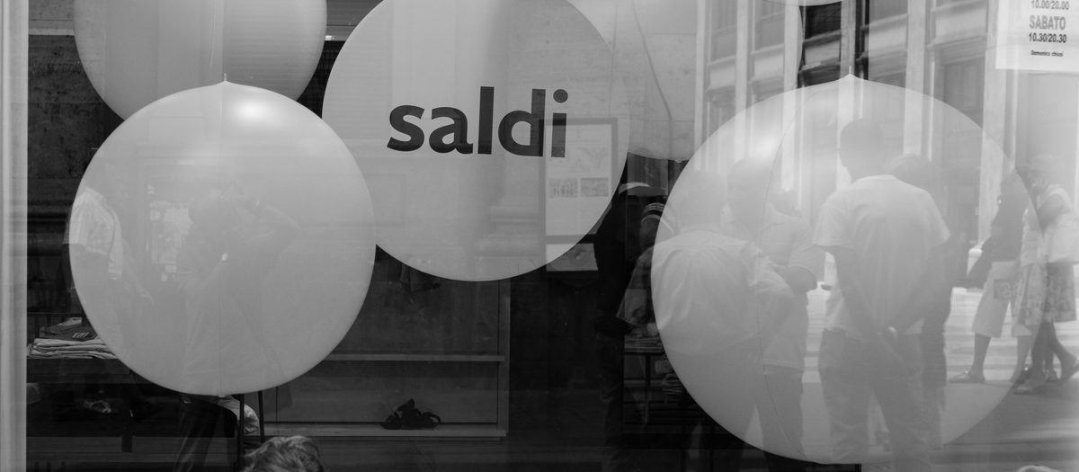 Een etalage in Napels met ballonnen voor de uitverkoop: tot 30%, tot 50%