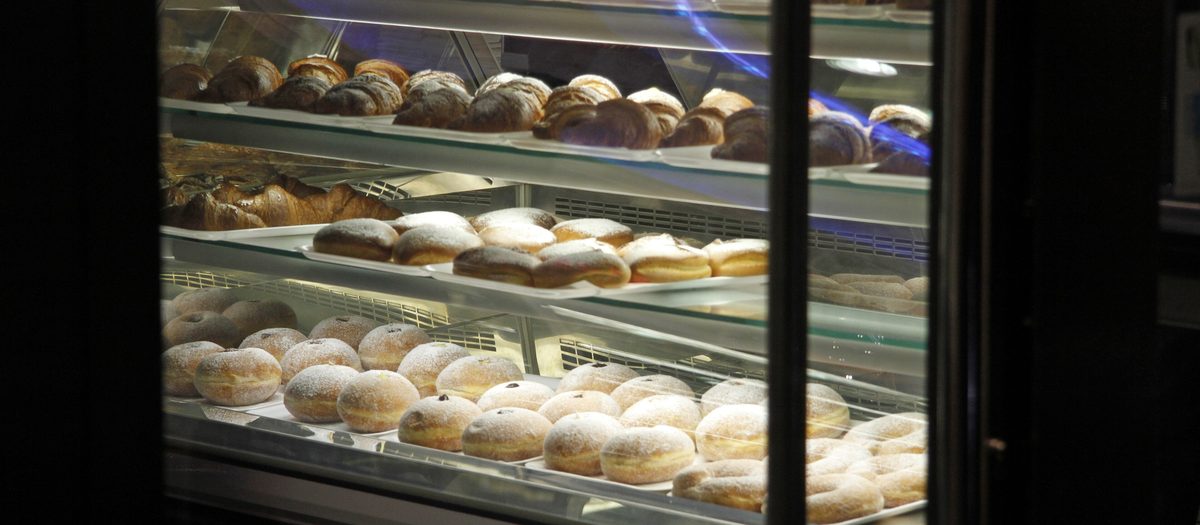 La vitrine éclairée d’un bar à Syracuse, pleine de cornetti, raviole et graffe