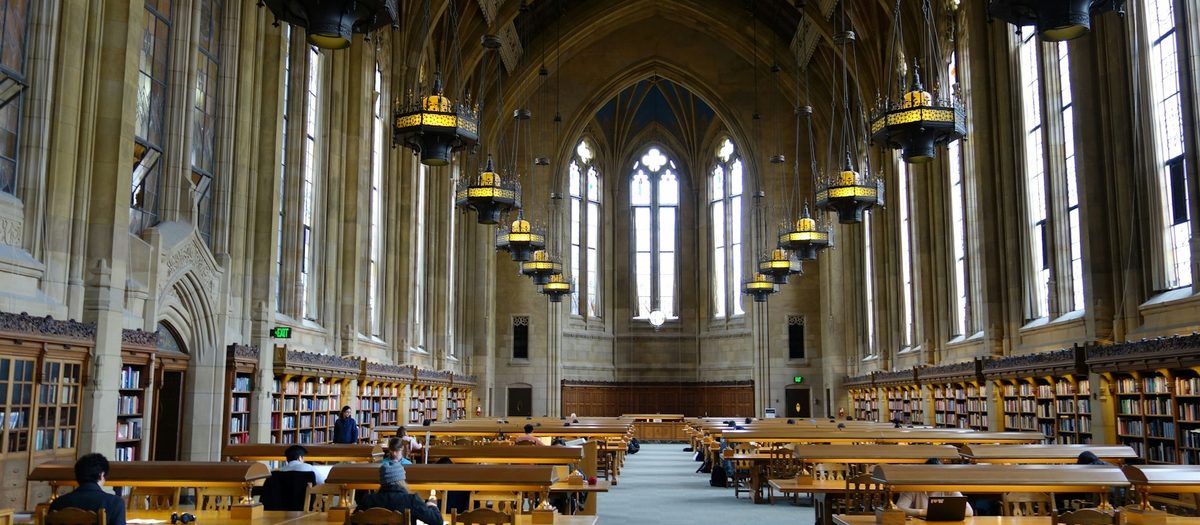 De leeszaal van een bibliotheek, met lampen en lange tafels · Italiaanse grammatica B1