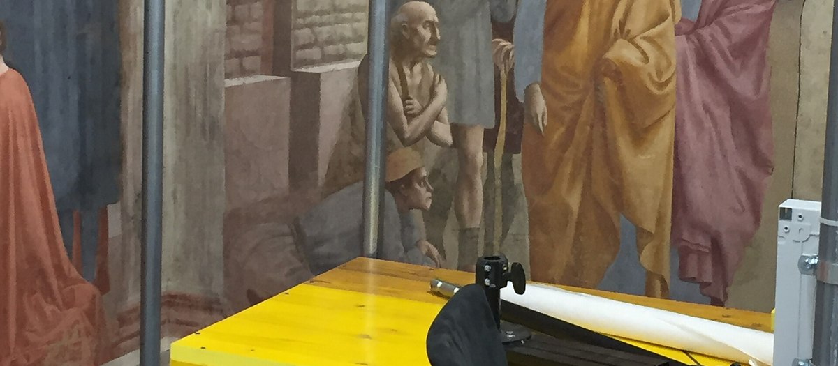 Een fresco achter het glas van een restauratiewerkplaats, met de kist en het materieel · Italiaanse grammatica B2