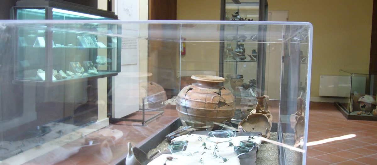 Een zaal van een stadsmuseum, met vitrines en vondsten
