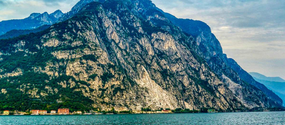 As montanhas a pique sobre o lago de Como, no braço de Lecco