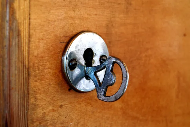 Una vecchia chiave di metallo nella serratura di una porta di legno