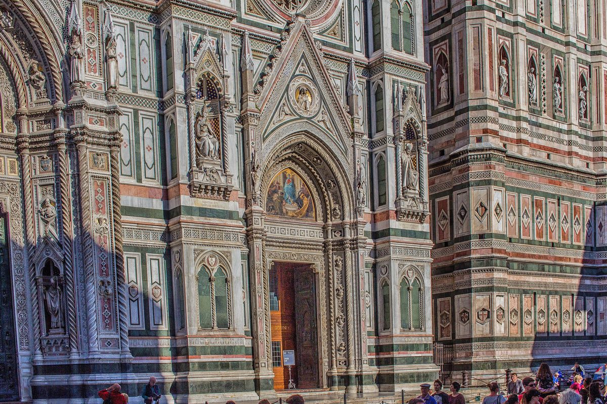 The marble facade of Florence cathedral, Santa Maria del Fiore, with visitors below