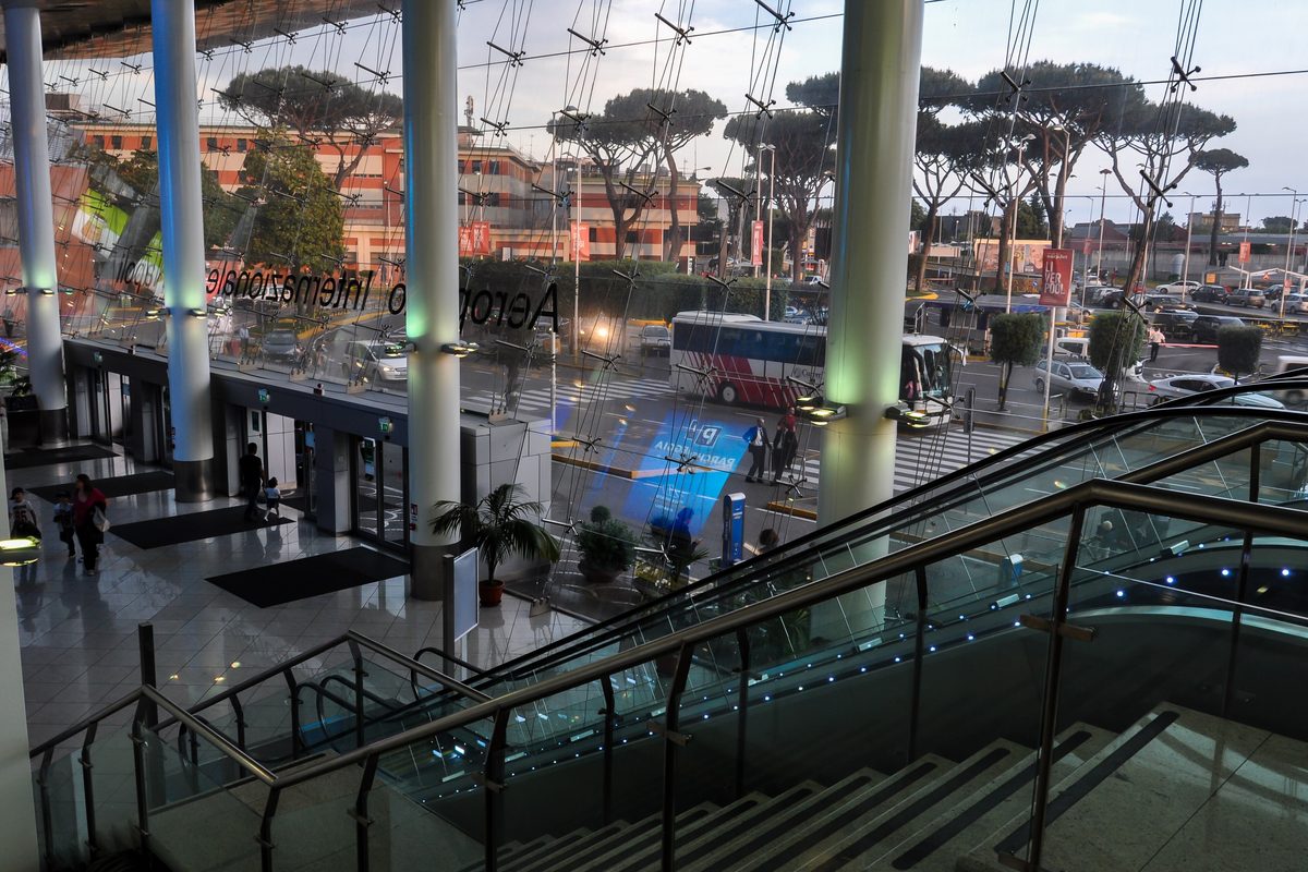 Escalators and glass walls inside the terminal of Naples airport