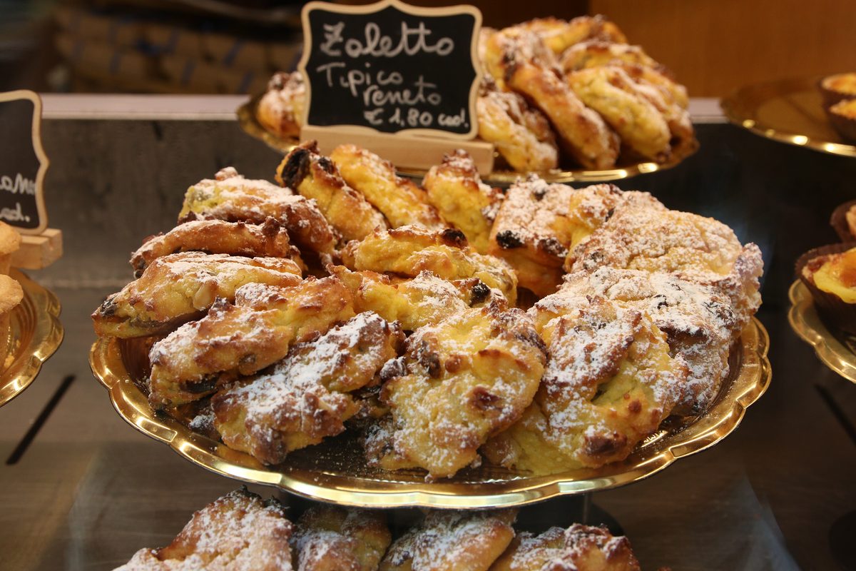 Pastries on trays with a price card in a pastry shop window in Verona