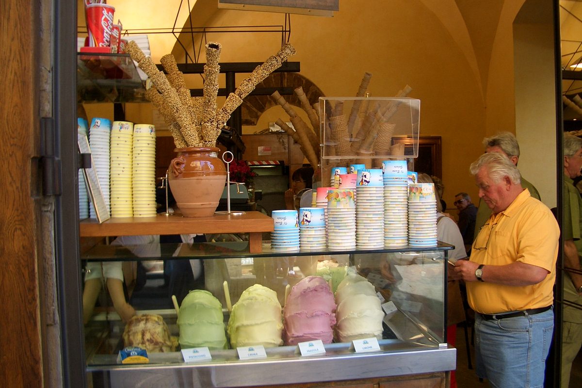 A customer choosing gelato at a counter near the Ponte Vecchio in Florence