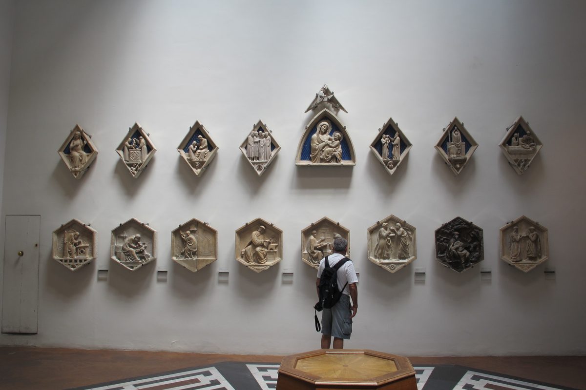 A visitor in the room of the bell-tower reliefs at the Museo dell'Opera del Duomo in Florence