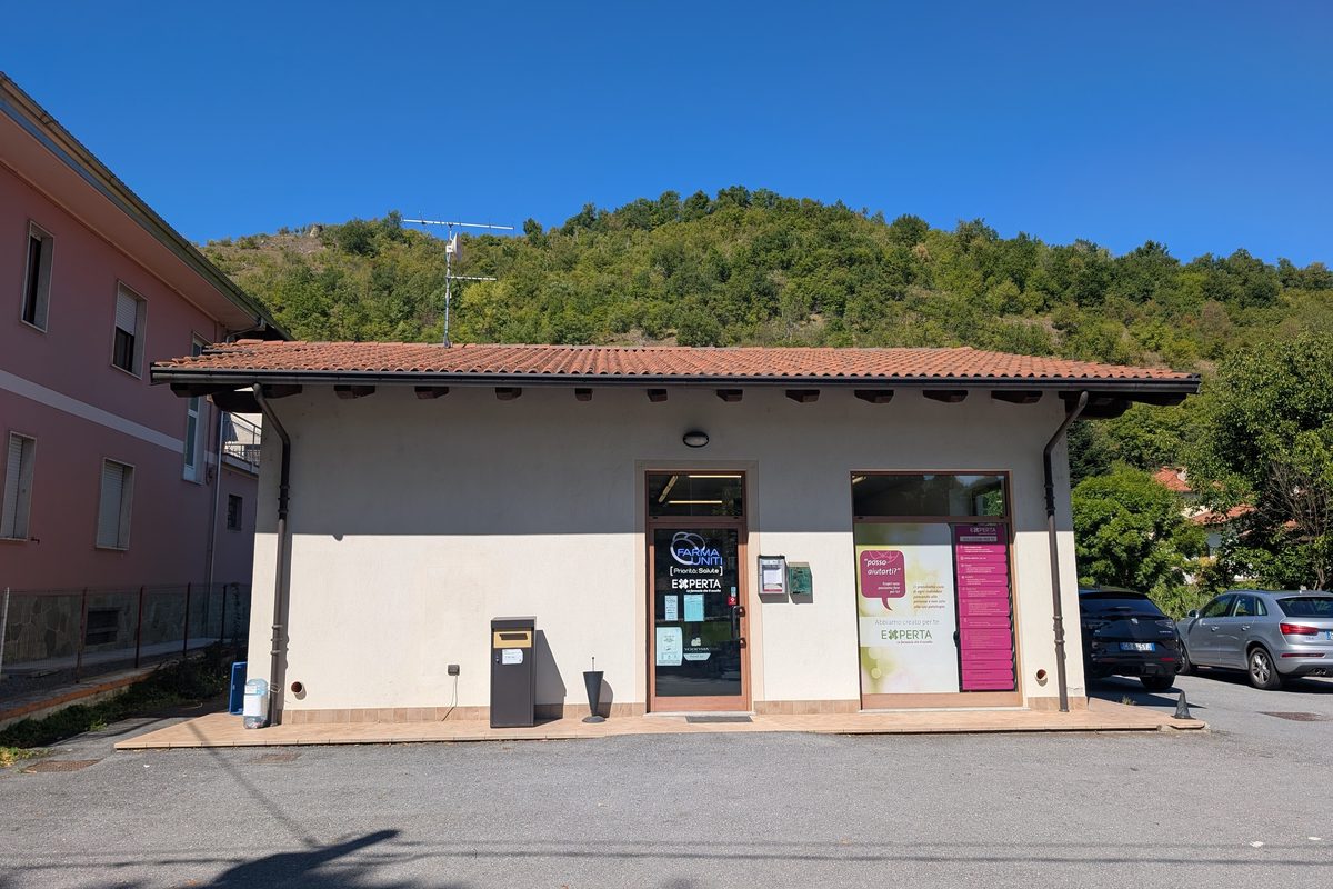 A small one-storey pharmacy building on the main road in Bagnasco, Piedmont