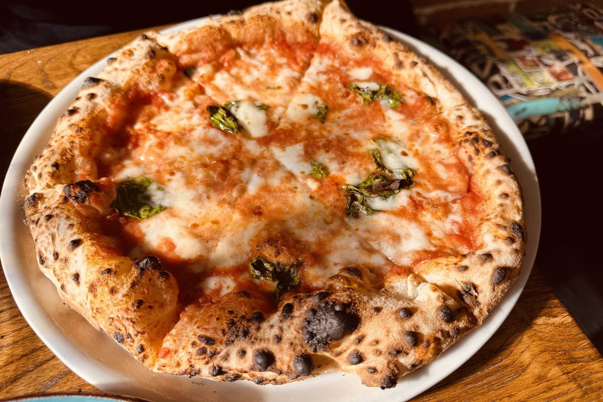 A whole Neapolitan-style pizza margherita on a plate
