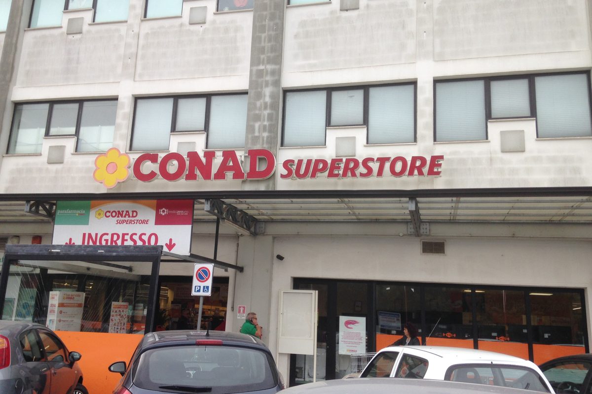 The entrance of a Conad Superstore with its sign, in Nuoro, Sardinia
