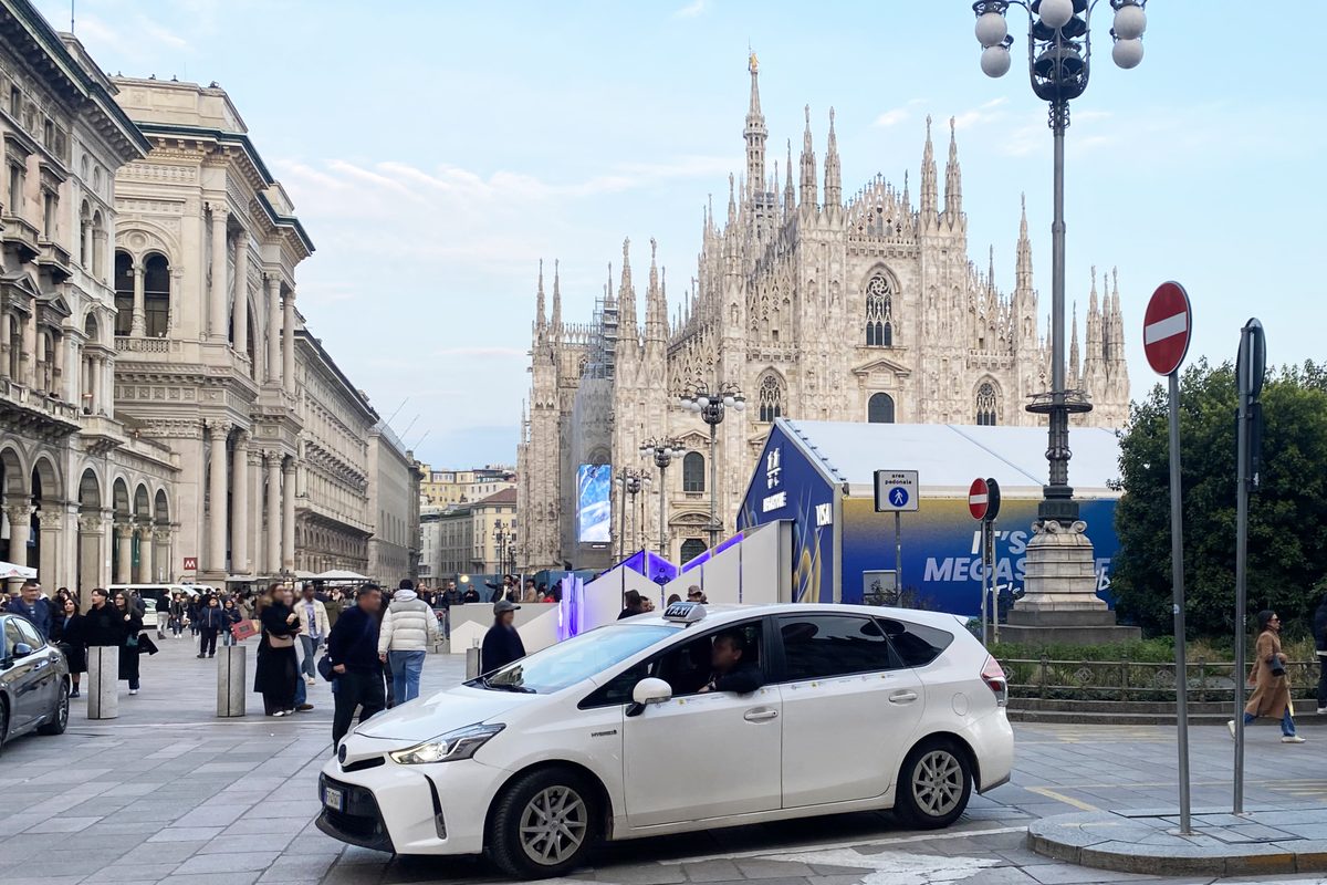 A white taxi near the cathedral in Milan