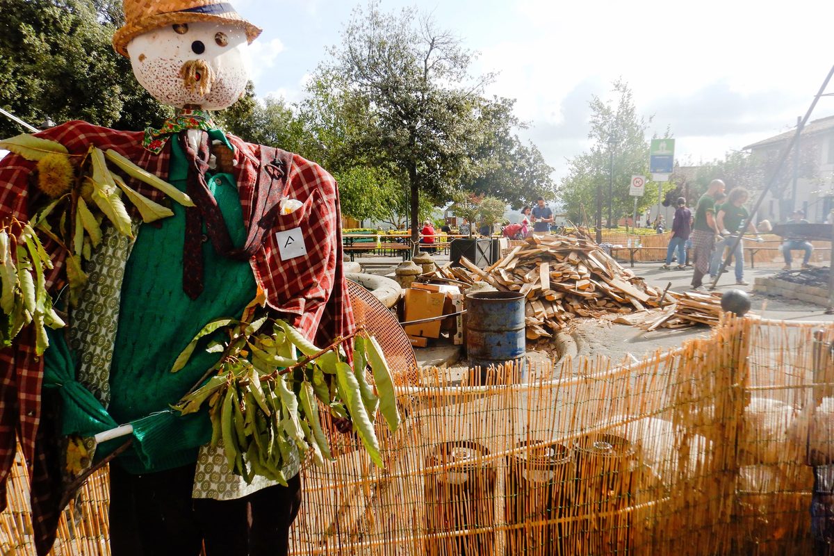 A scarecrow decoration and stacked wood at the chestnut festival in Manziana, Lazio