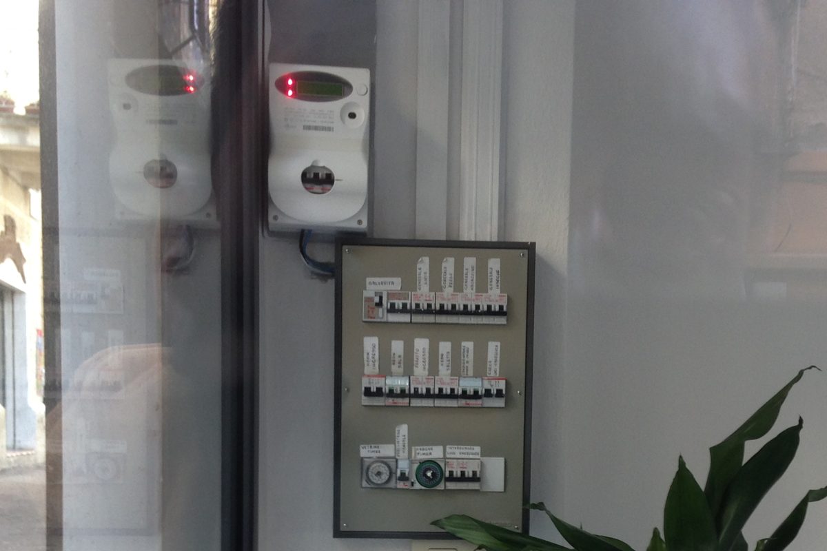 An electrical panel with switches, timers and an Enel electricity meter on a wall