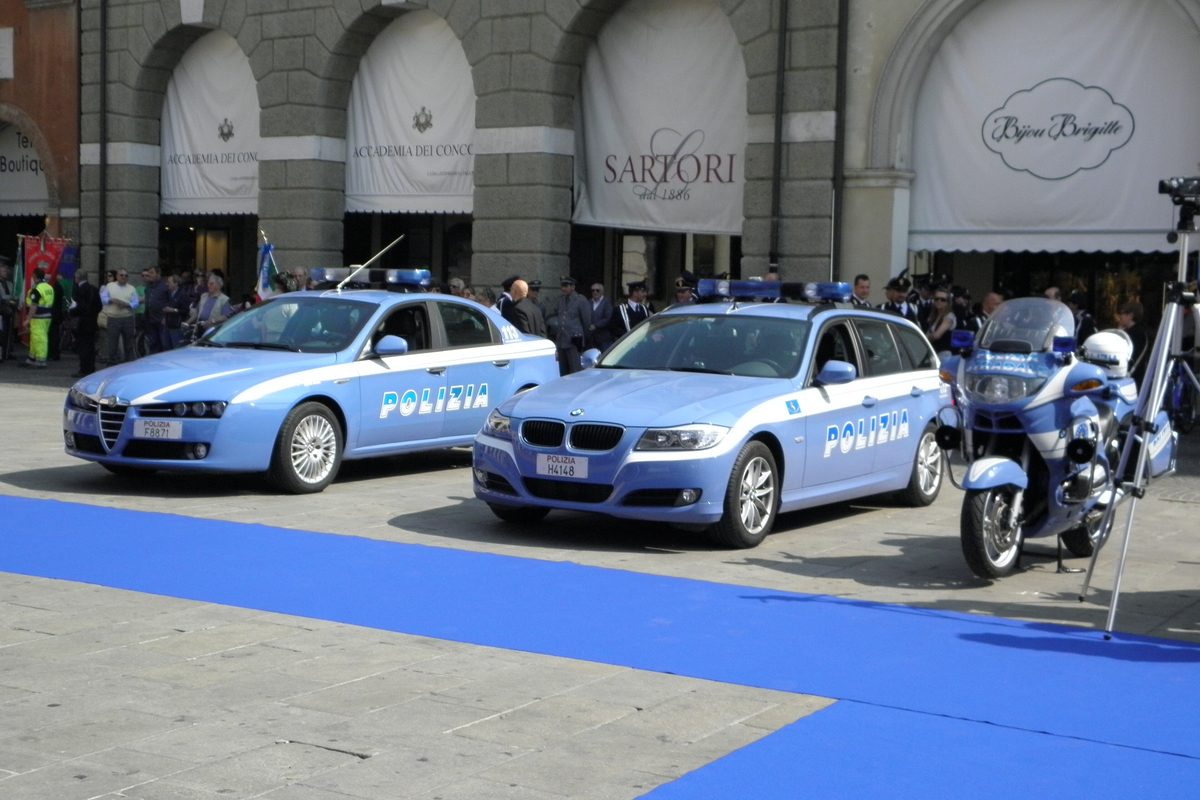 Polizia di Stato cars and a motorbike lined up in a square in Rovigo