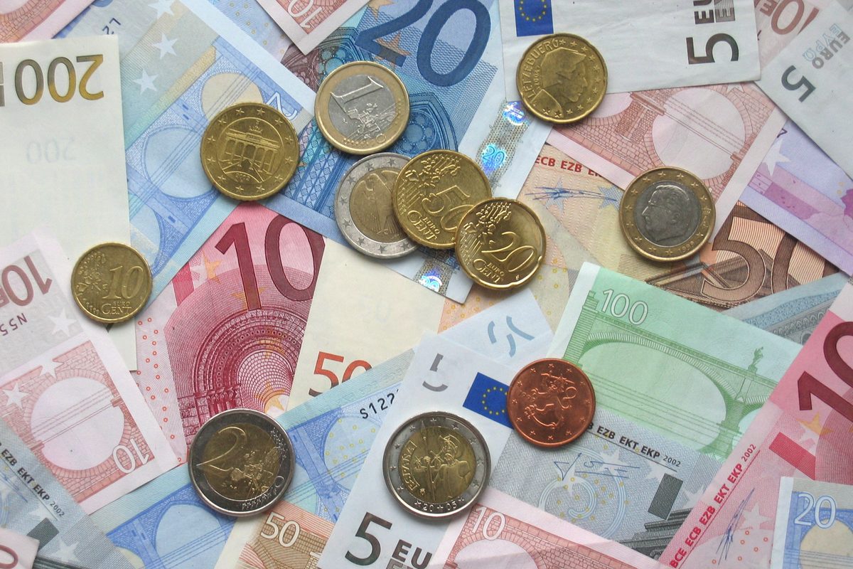 Euro coins and banknotes spread on a table