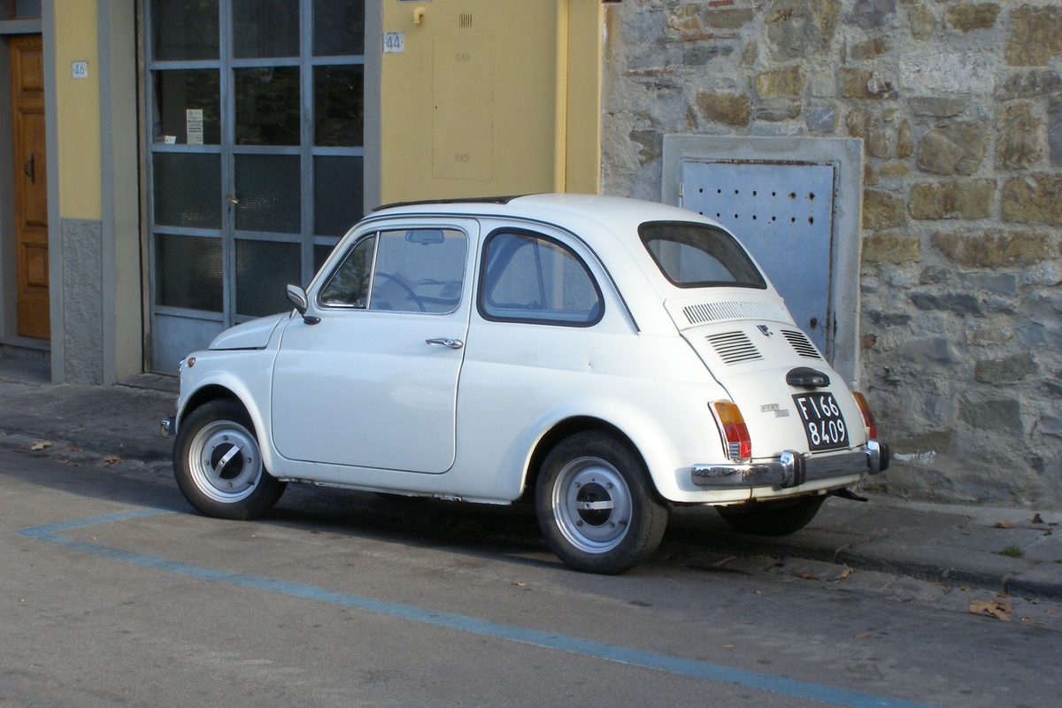 A classic Fiat 500 parked in a street in Fiesole