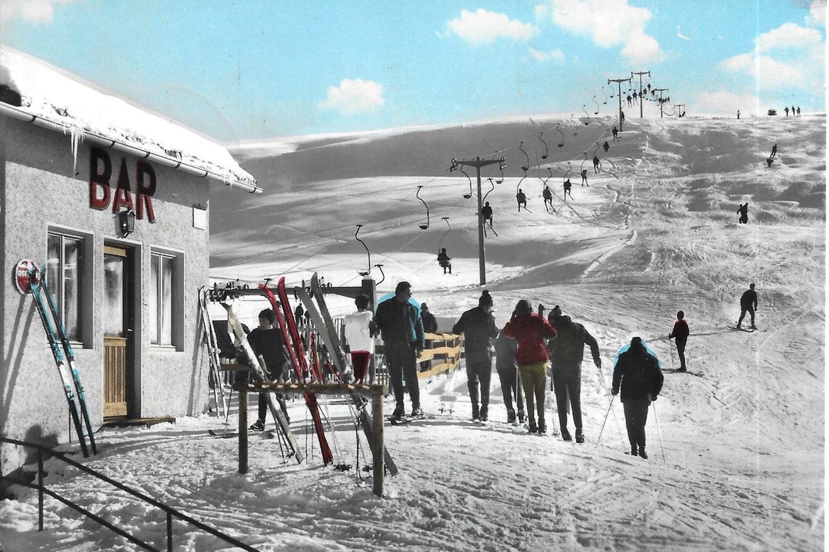 Skiers next to a bar and a chairlift on the Alpe di Siusi in 1961