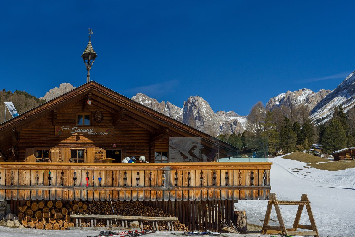 The Sangon mountain hut with its terrace in the snow, below the Odle peaks in the Dolomites