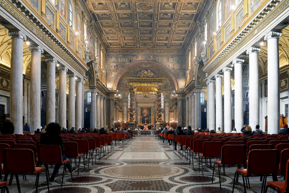 Visitors seated in the nave of Santa Maria Maggiore in Rome