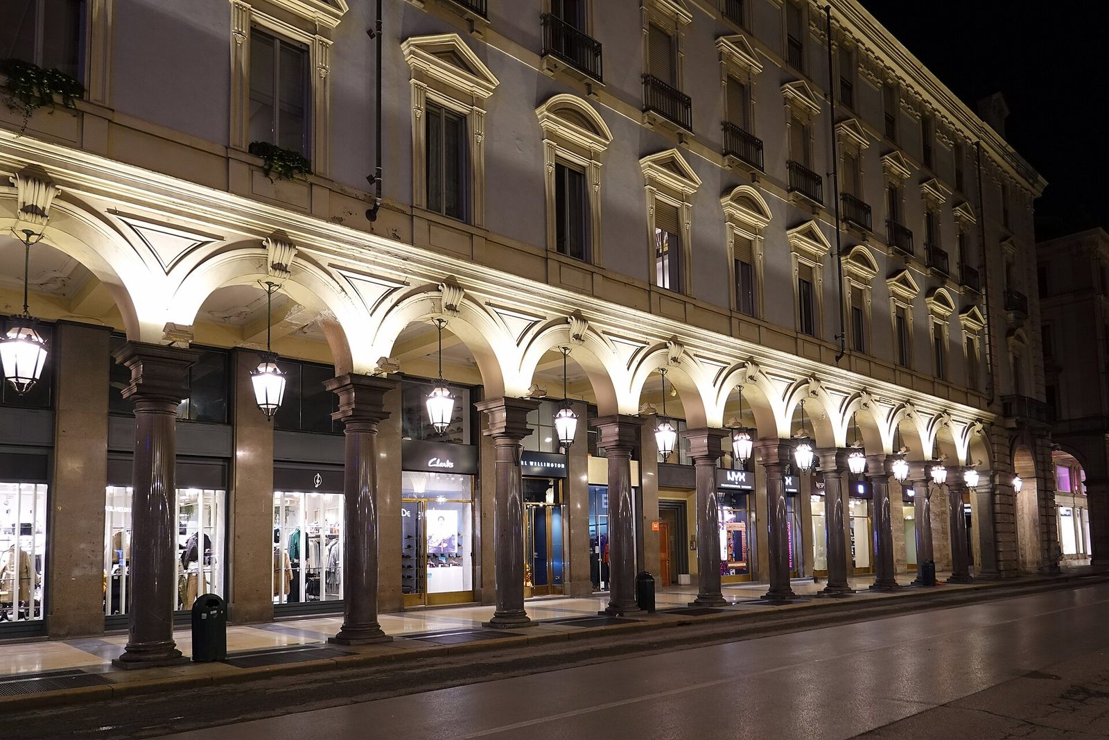 De verlichte zuilengangen van de Via Roma in Turijn bij avond
