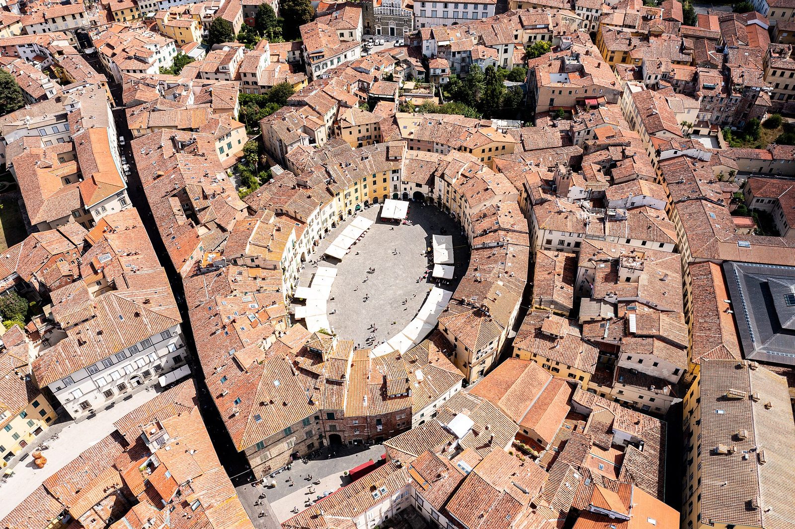 De daken en straatjes van Lucca van bovenaf, met de ovale Piazza dell'Anfiteatro in het midden